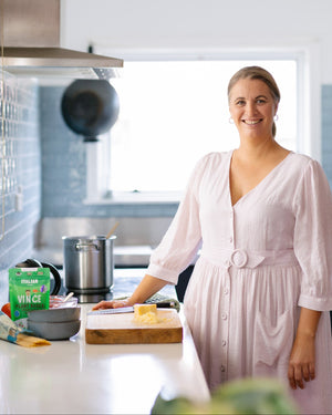 Vince Veggie Smugglers founder and mum-chef standing in a home kitchen with ready-made hidden veggie meal ingredients for kids in NZ and Australia.